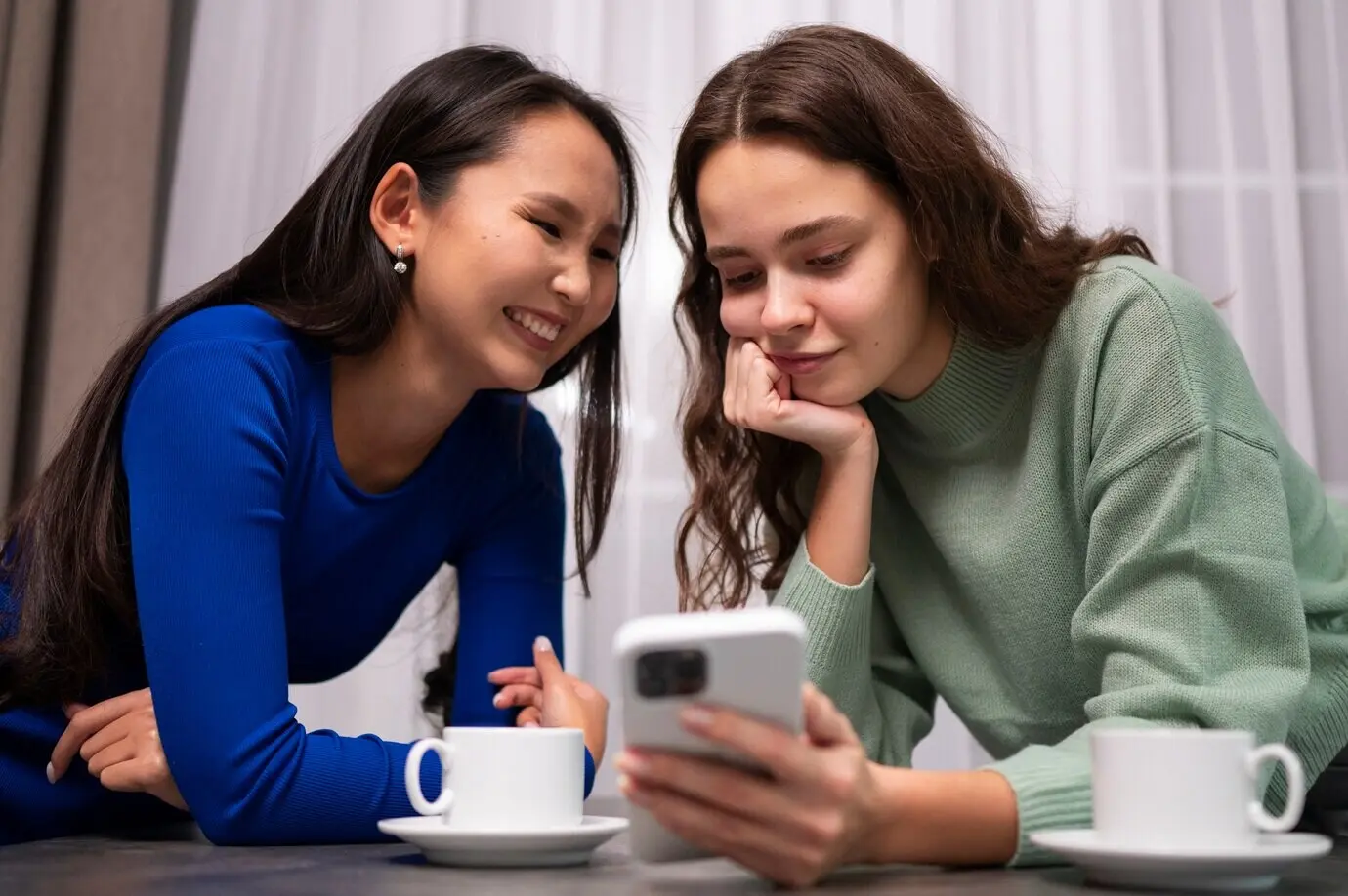 Frauen beim Lesen von Handynachrichten, halbnahe Aufnahme